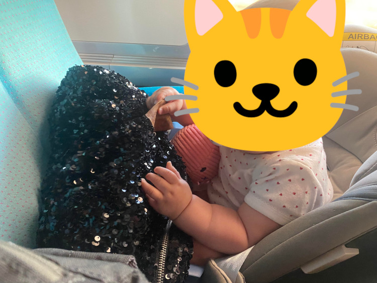 Esmée jouant dans le train avec mon sac à main et sa peluche